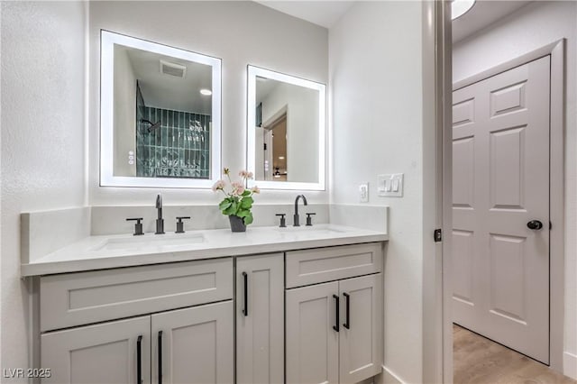 bathroom with double vanity, visible vents, and a sink