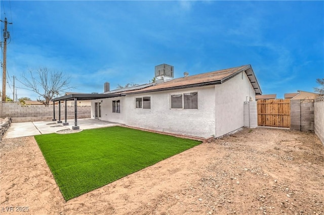 rear view of house with a patio area, stucco siding, a lawn, and a fenced backyard