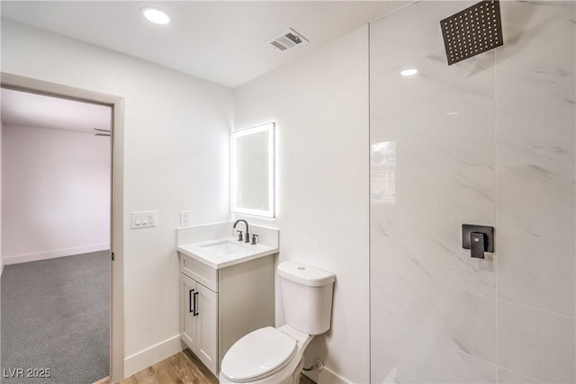 bathroom with visible vents, baseboards, toilet, vanity, and a shower