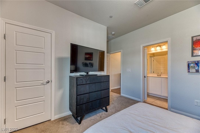 bedroom with a sink, baseboards, visible vents, and light carpet