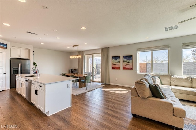 kitchen with dark wood-style floors, open floor plan, stainless steel appliances, and visible vents