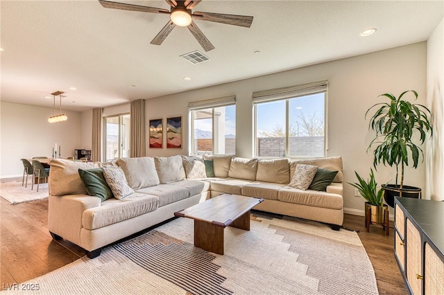 living room featuring recessed lighting, visible vents, baseboards, and wood finished floors