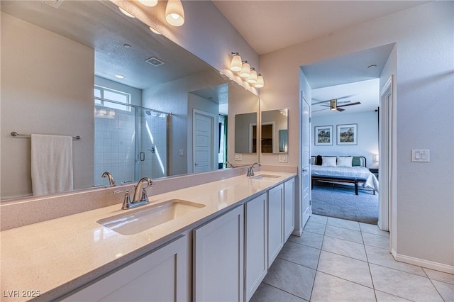 bathroom with a ceiling fan, double vanity, a stall shower, a sink, and tile patterned flooring