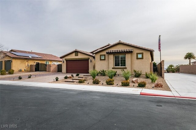 mediterranean / spanish-style home featuring a gate, fence, driveway, and stucco siding