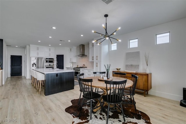 dining area with visible vents, light wood-style flooring, recessed lighting, baseboards, and a chandelier