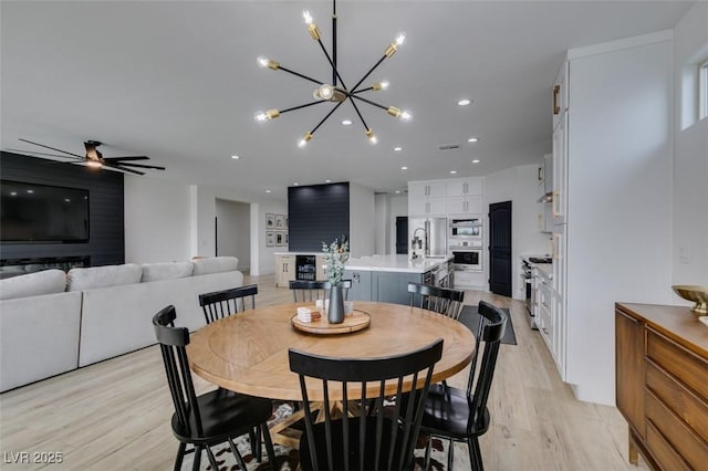 dining area with ceiling fan with notable chandelier, recessed lighting, and light wood-type flooring