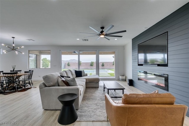 living area with a wealth of natural light, wooden walls, and wood finished floors