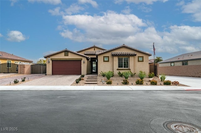 mediterranean / spanish-style house with an attached garage, a gate, fence, and driveway