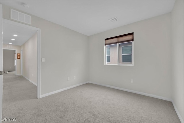 empty room featuring recessed lighting, visible vents, light colored carpet, and baseboards