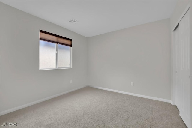 carpeted empty room featuring visible vents and baseboards