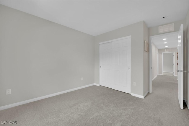 unfurnished bedroom featuring carpet flooring, baseboards, and a closet