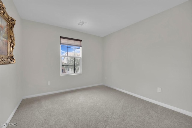 carpeted spare room with visible vents and baseboards