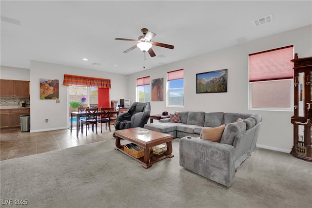 living room featuring tile patterned floors, carpet, visible vents, and baseboards