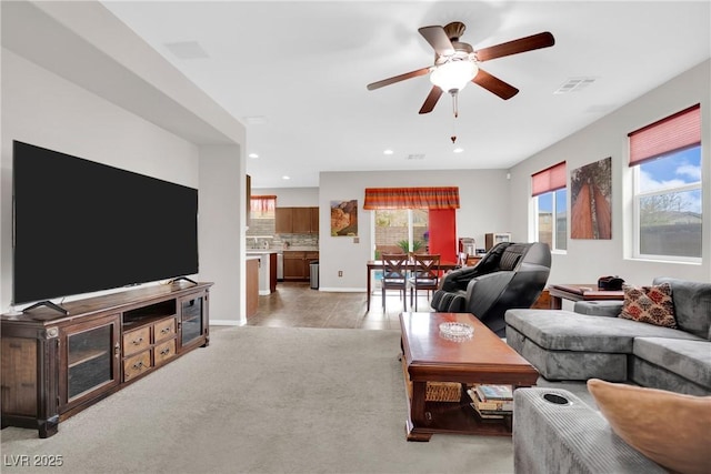 living area featuring a ceiling fan, visible vents, baseboards, recessed lighting, and light colored carpet