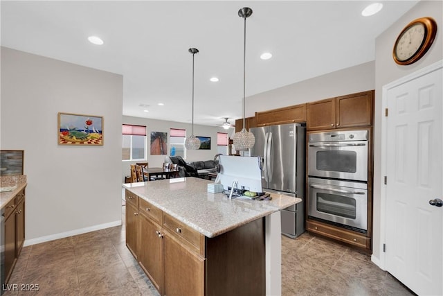 kitchen with brown cabinets, light stone counters, a center island, recessed lighting, and stainless steel appliances