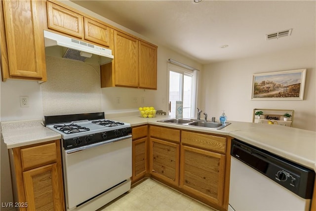 kitchen with visible vents, under cabinet range hood, light floors, white appliances, and a sink