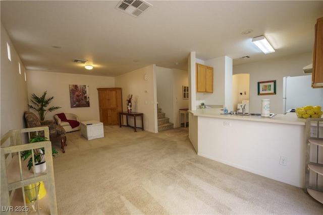 kitchen with light carpet, visible vents, light countertops, and freestanding refrigerator