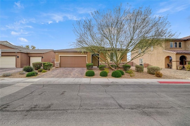 view of front of property with stucco siding, a garage, driveway, and a tile roof