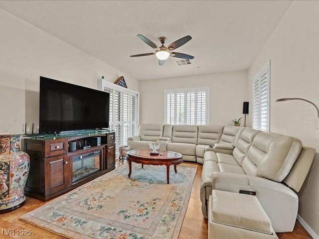 living room featuring visible vents and a ceiling fan