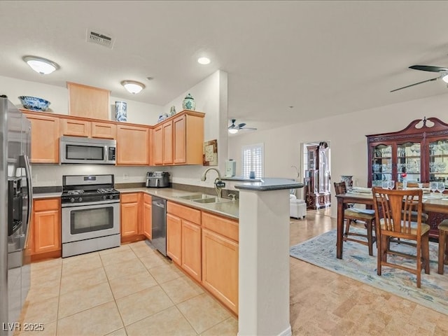 kitchen with visible vents, a ceiling fan, a sink, appliances with stainless steel finishes, and a peninsula