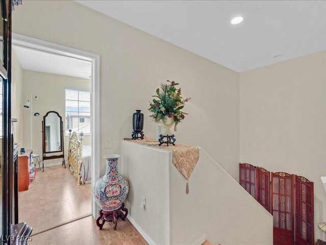 hallway with recessed lighting, baseboards, and an upstairs landing