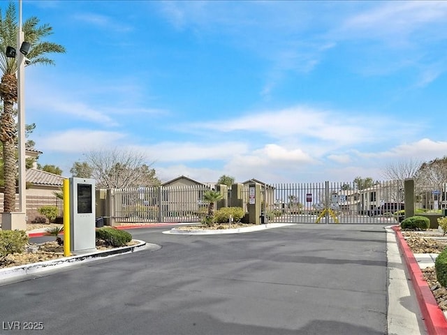 view of road with a gated entry, curbs, and a gate