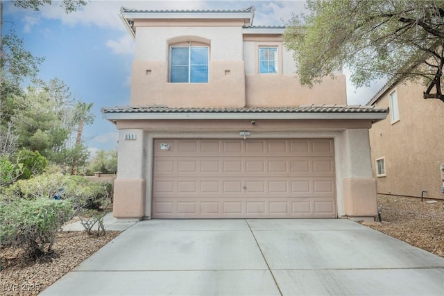 view of front facade featuring concrete driveway, a tiled roof, and stucco siding