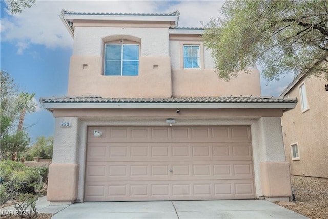 view of front facade featuring stucco siding, a garage, concrete driveway, and a tile roof