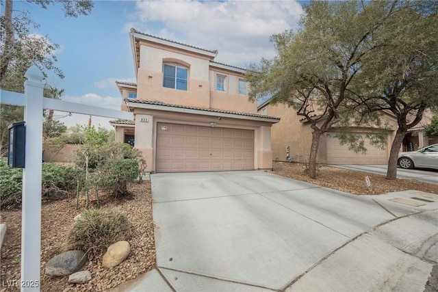 mediterranean / spanish home with a tile roof, a garage, driveway, and stucco siding