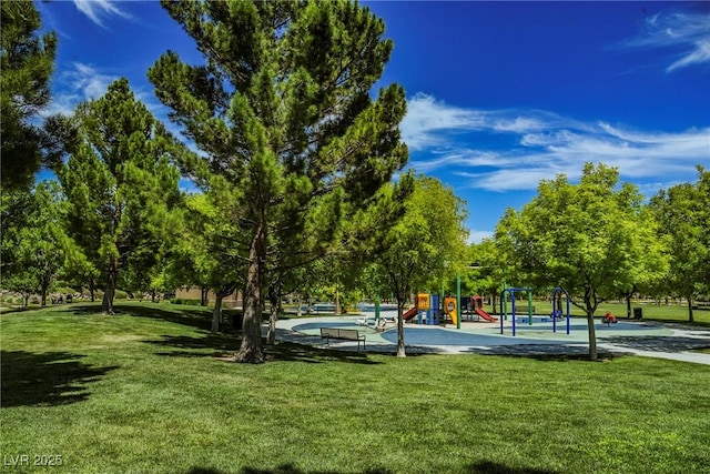 view of property's community featuring playground community and a yard