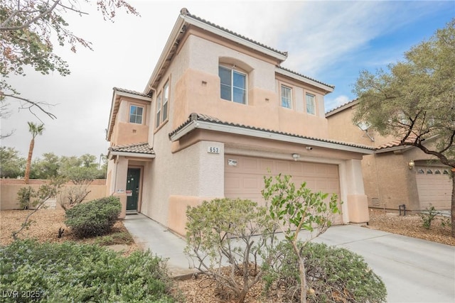 mediterranean / spanish home with stucco siding, a tiled roof, and concrete driveway