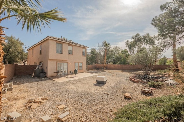 rear view of property featuring stucco siding, central AC, a fenced backyard, and a patio area