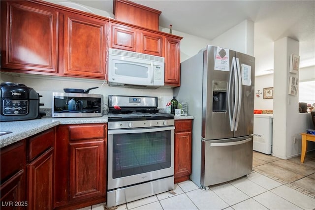 kitchen with light tile patterned flooring, dark brown cabinets, and stainless steel appliances