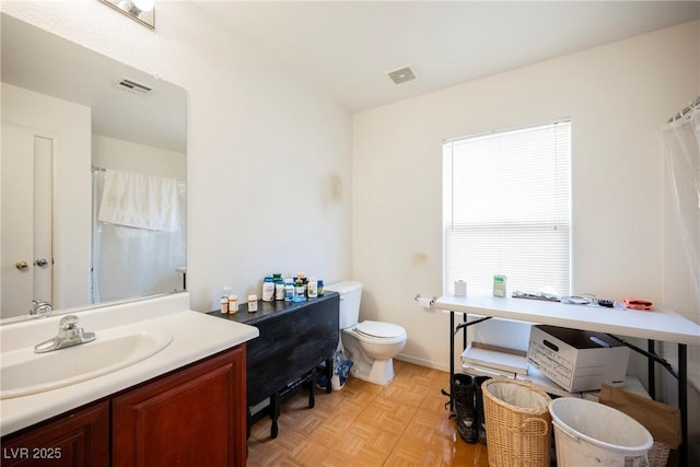 bathroom featuring visible vents, toilet, vanity, and a shower with curtain