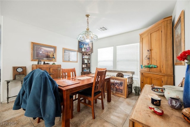 dining space featuring visible vents and an inviting chandelier