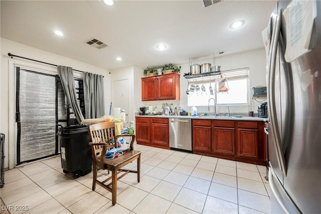 kitchen featuring visible vents, light countertops, light tile patterned floors, stainless steel appliances, and a sink