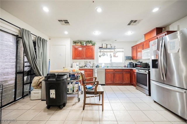 kitchen with light tile patterned floors, stainless steel appliances, and visible vents