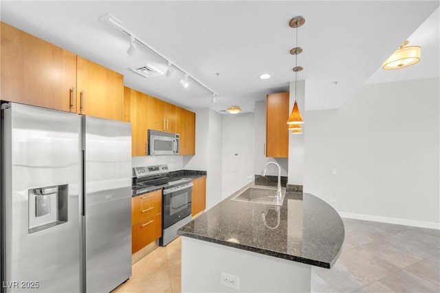 kitchen featuring visible vents, dark stone counters, brown cabinets, appliances with stainless steel finishes, and a sink