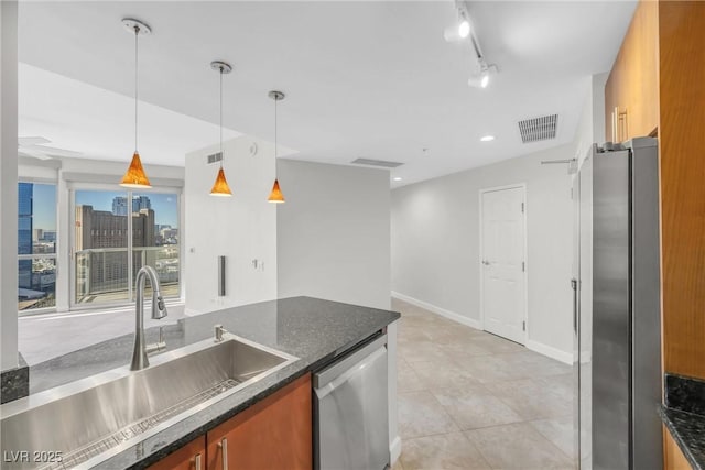 kitchen with visible vents, pendant lighting, a sink, appliances with stainless steel finishes, and brown cabinetry