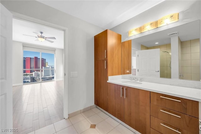 full bath featuring vanity, baseboards, visible vents, a tile shower, and ceiling fan