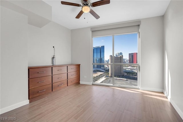 spare room with baseboards, a city view, and wood finished floors