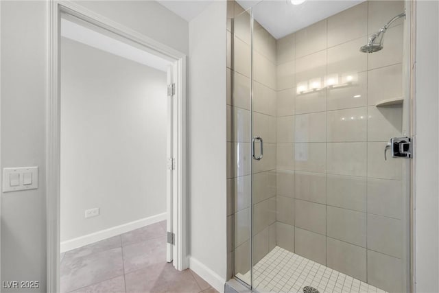 bathroom featuring tile patterned floors, a stall shower, and baseboards