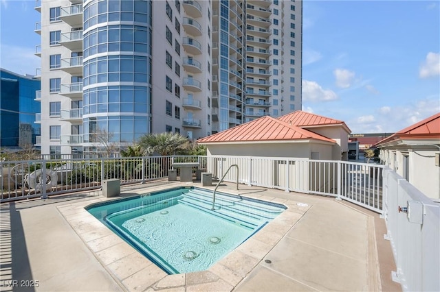 view of pool with a patio area and fence