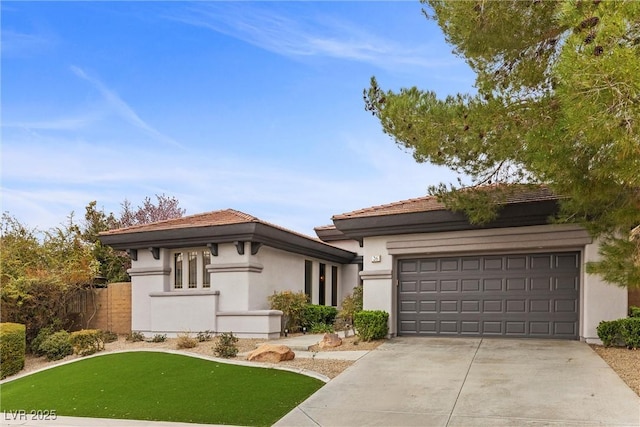 prairie-style home with an attached garage, fence, driveway, and stucco siding