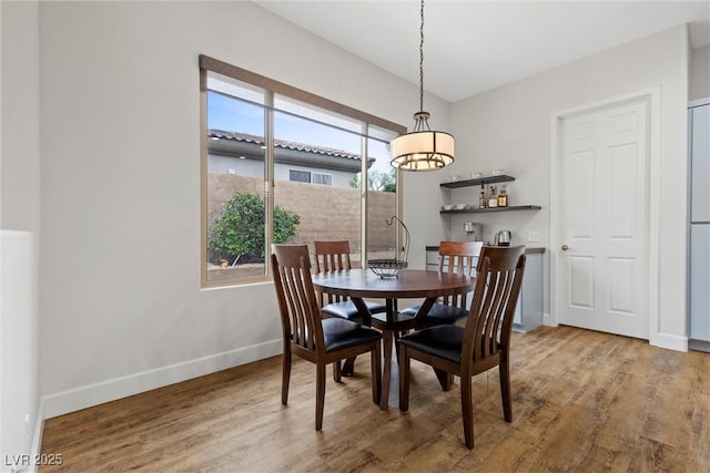 dining space featuring baseboards and wood finished floors