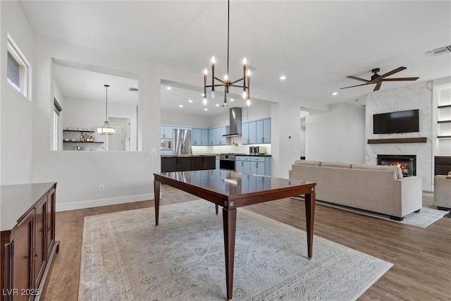 interior space featuring visible vents, dark wood-type flooring, a ceiling fan, recessed lighting, and a premium fireplace