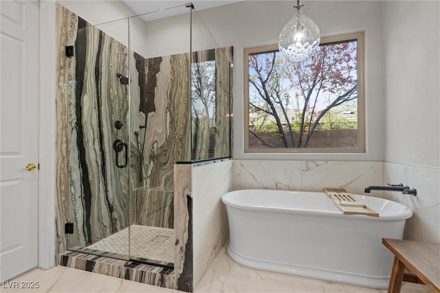 full bathroom with tile walls, marble finish floor, a marble finish shower, and a freestanding bath