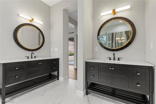 bathroom featuring two vanities, marble finish floor, and a sink