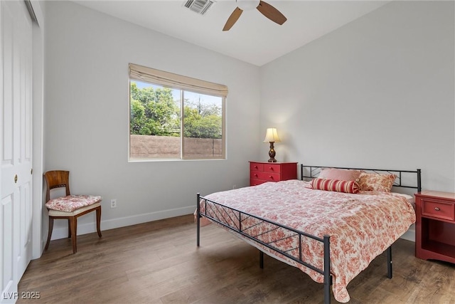 bedroom with visible vents, baseboards, wood finished floors, a closet, and a ceiling fan