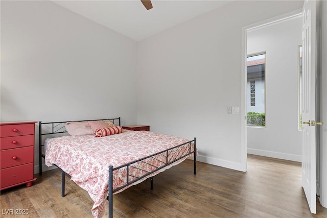 bedroom featuring a ceiling fan, multiple windows, wood finished floors, and baseboards